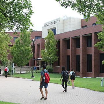 Students walk outside the Student Center building on the 赌钱app可以微信提现 main campus.